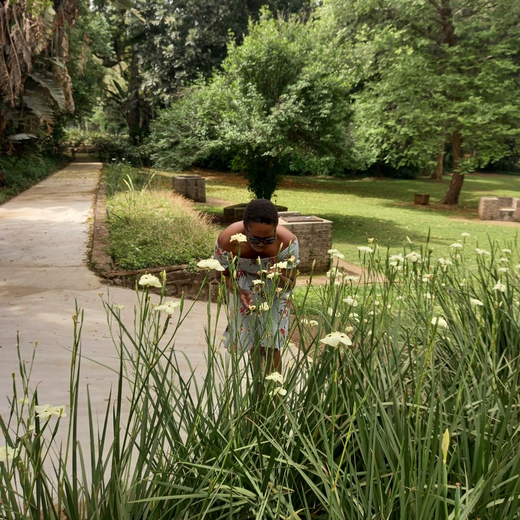 Woman looking at yellow flowers in the Botanical Gardens during spring time.